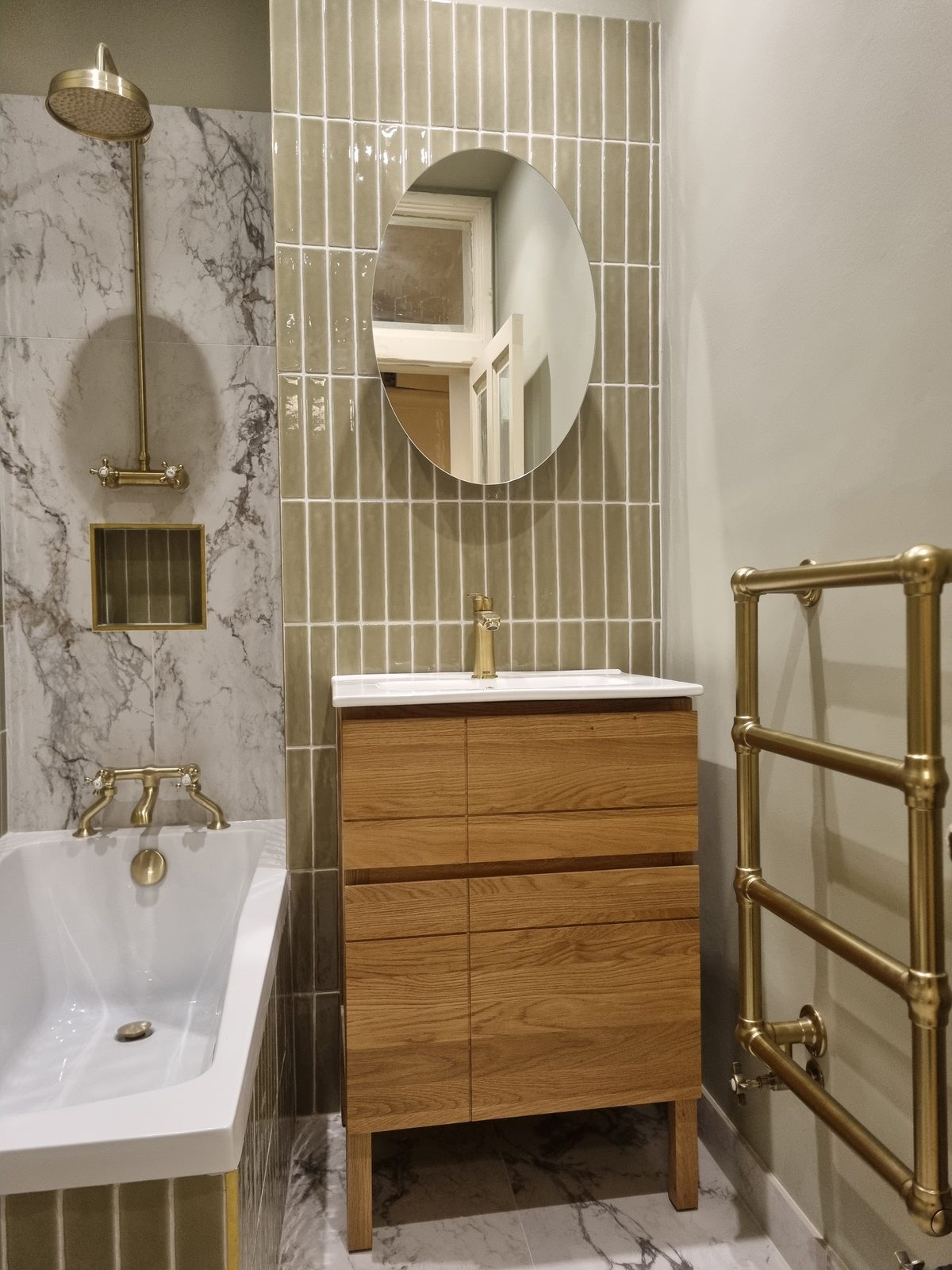 A marble shower, oak vanity and brass towel warmer — JAG Construction, Devonshire House